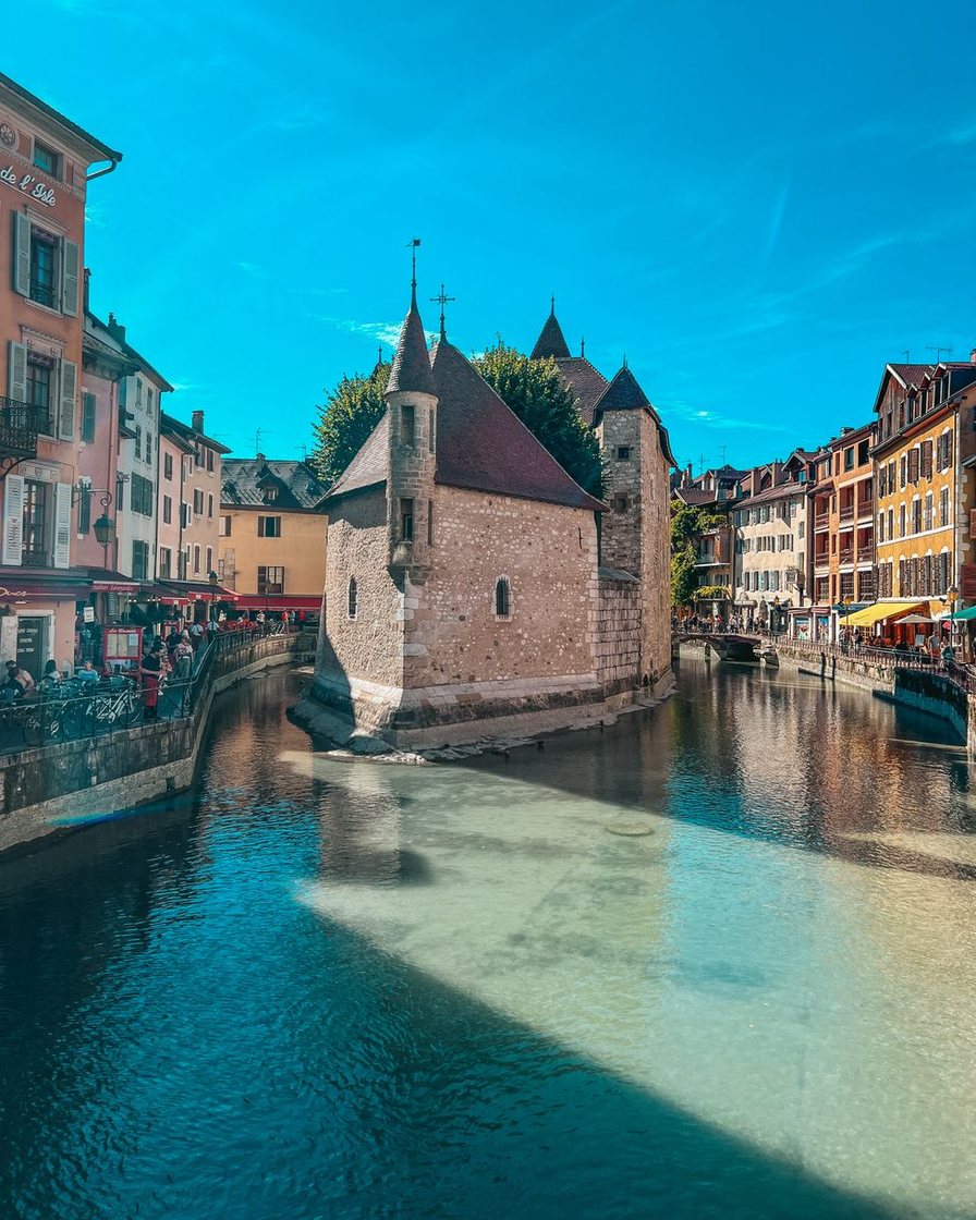 Canal de la vieille ville d'Annecy vu d'en haut entre des maisons à volets, franchi par un pont de pierre
